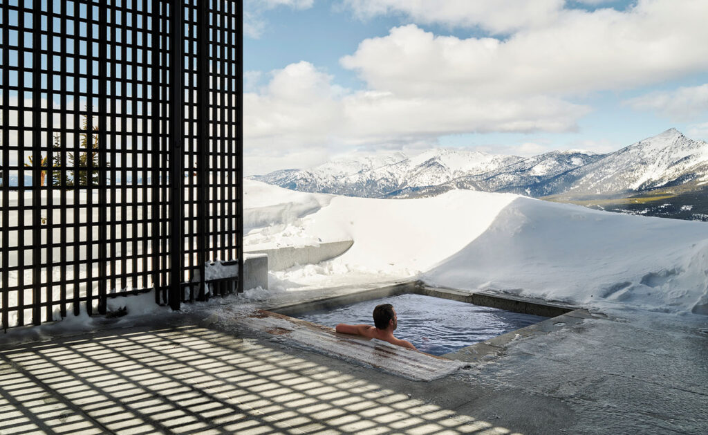 A man in a hot tub in a snowy area