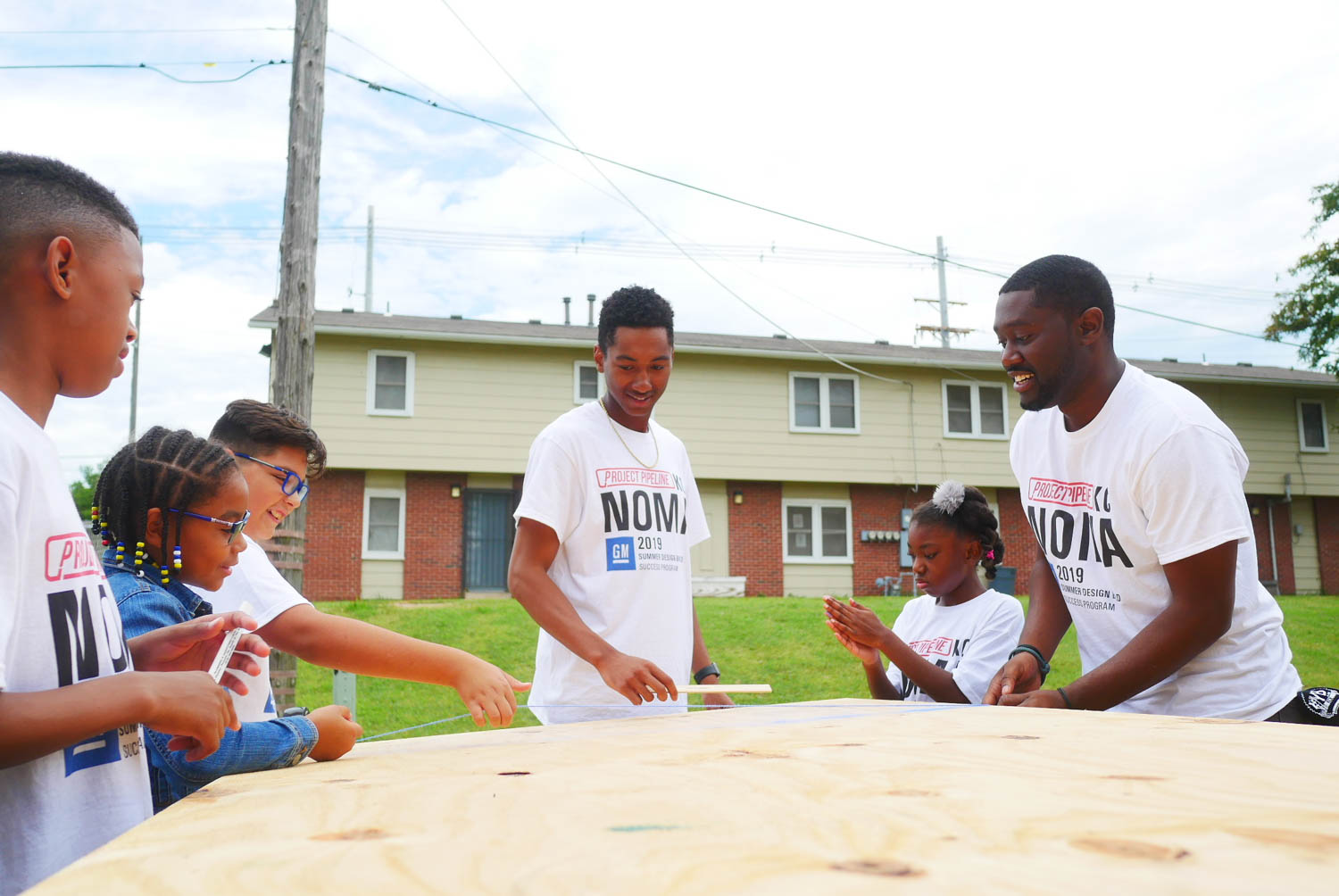 Lee standing with other children working on projects