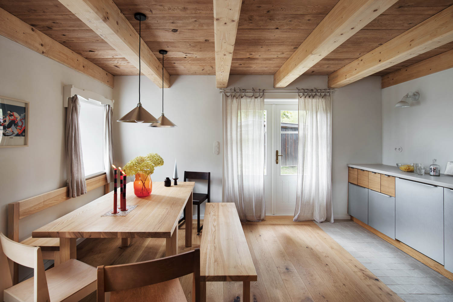 interior of cottage with wooden table and benches and wooden beam ceilings