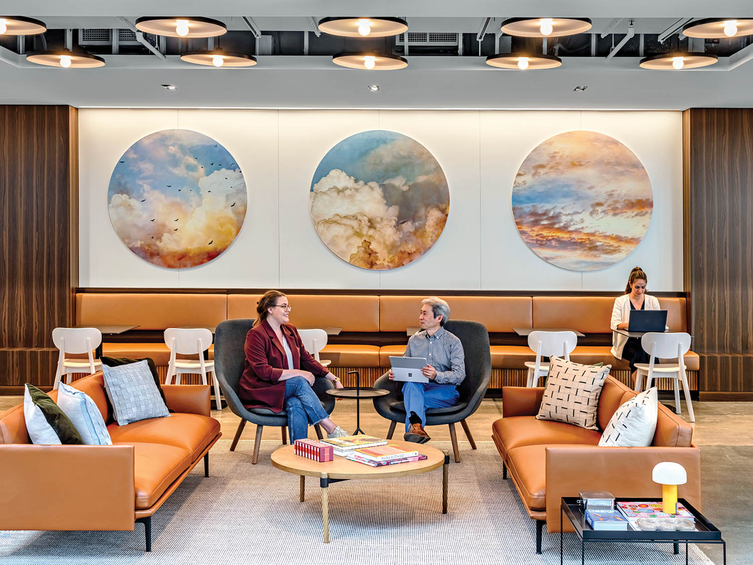 two people sitting at lobby area with dark orange couches