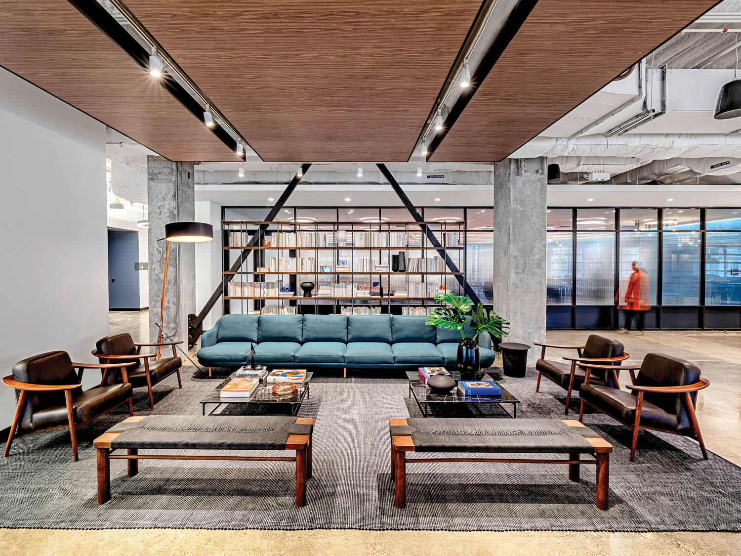 atrium lounge with long blue couch, cement pillars and seating