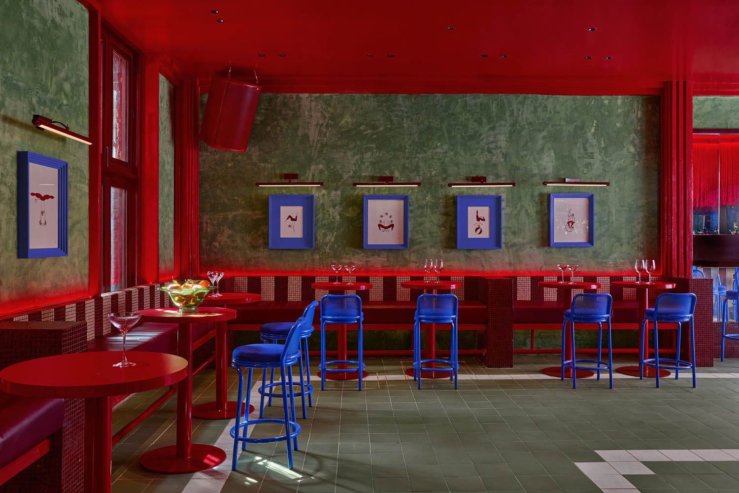 dining area with bright red borders and blue chairs by Maye Ruiz