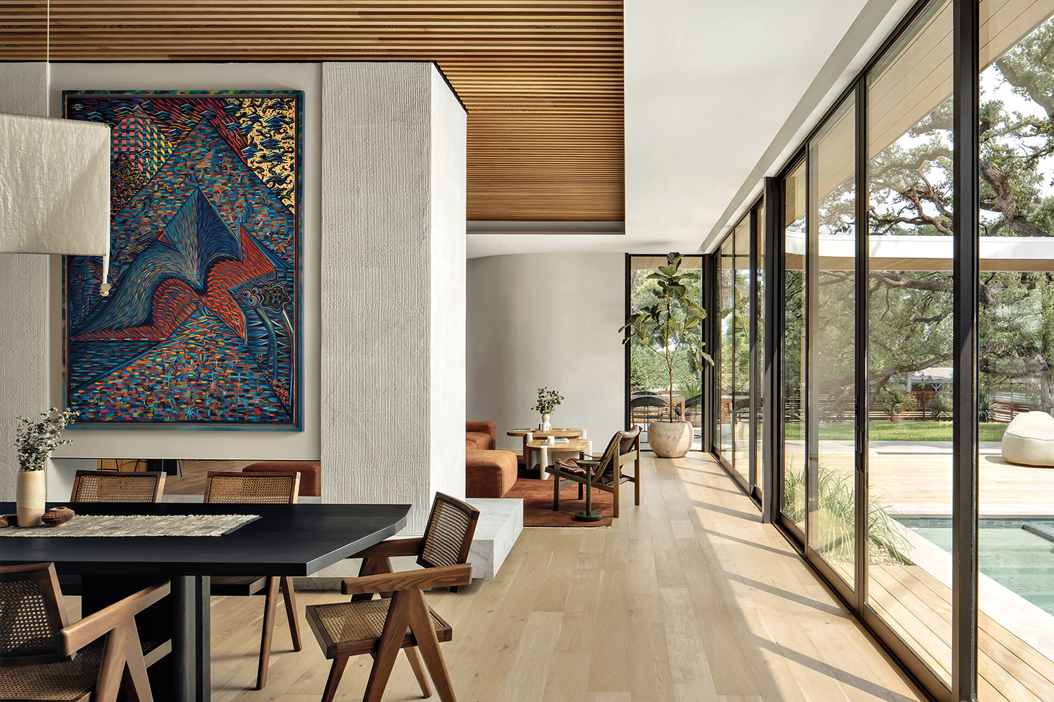 modern dining room with a Zach Harris painting above an oxidized-walnut table