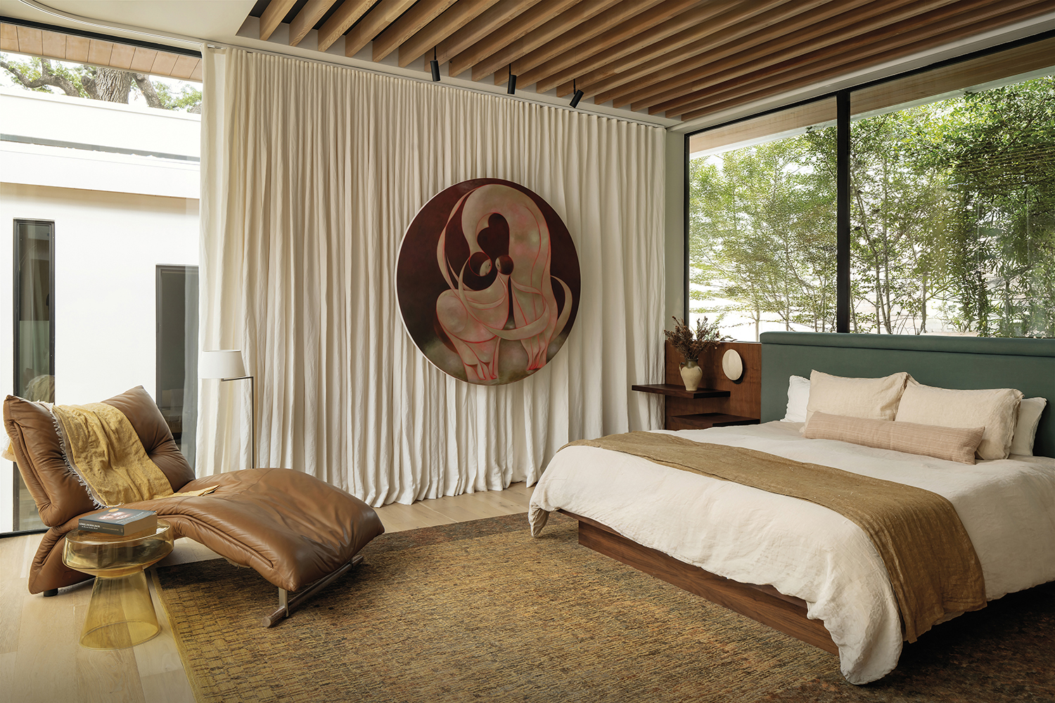 contemporary bedroom with a warm neutral palette and views of oak trees outside