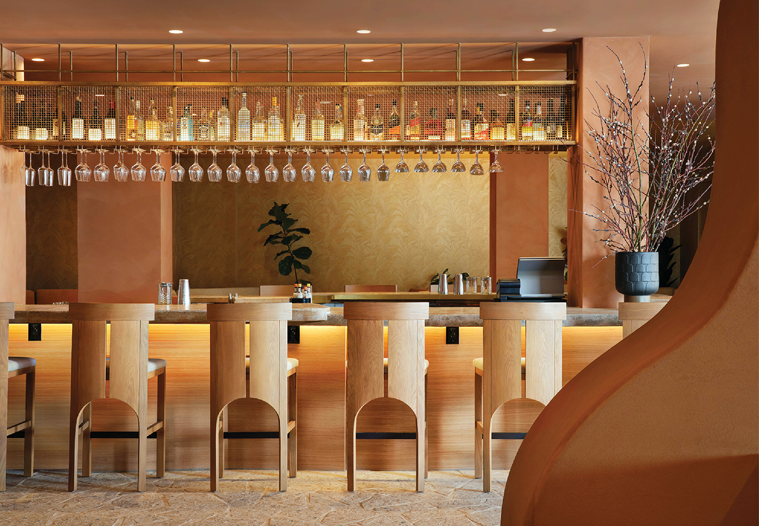 A bar with a bunch of wine glasses hanging from the ceiling