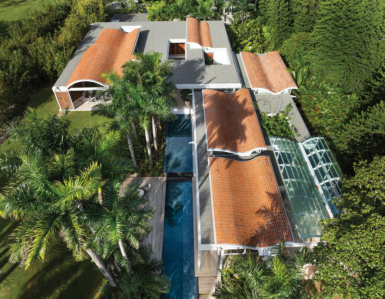 A house with a pool surrounded by palm trees