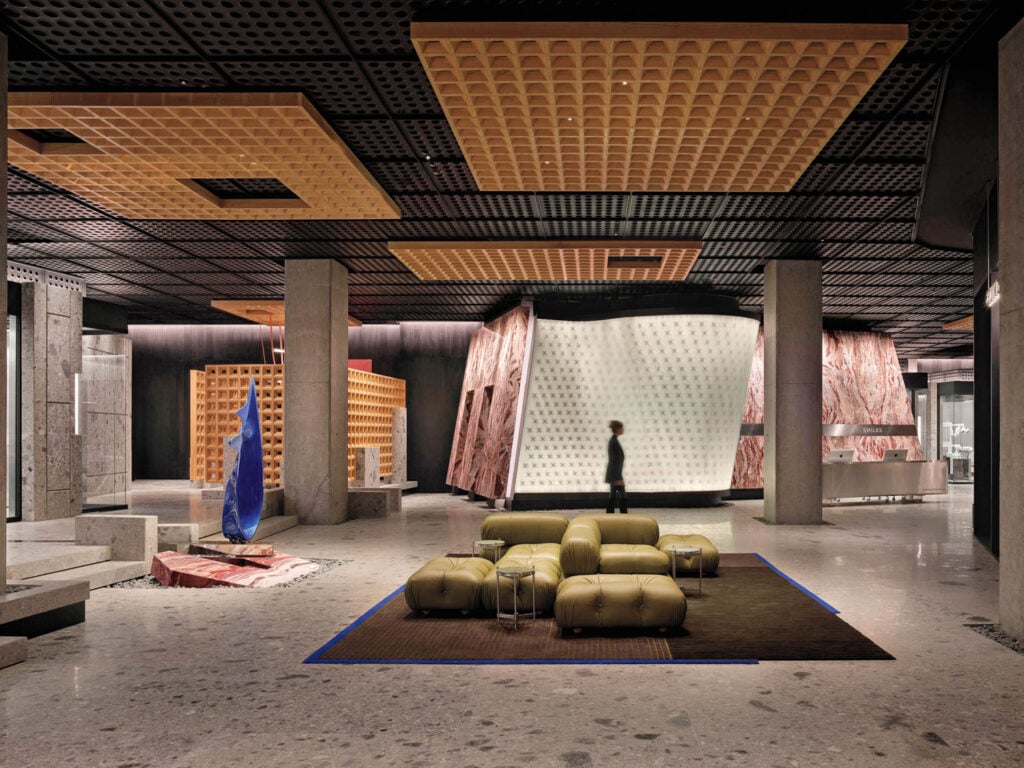 Modern interior with geometric ceiling, abstract art, and olive green seating