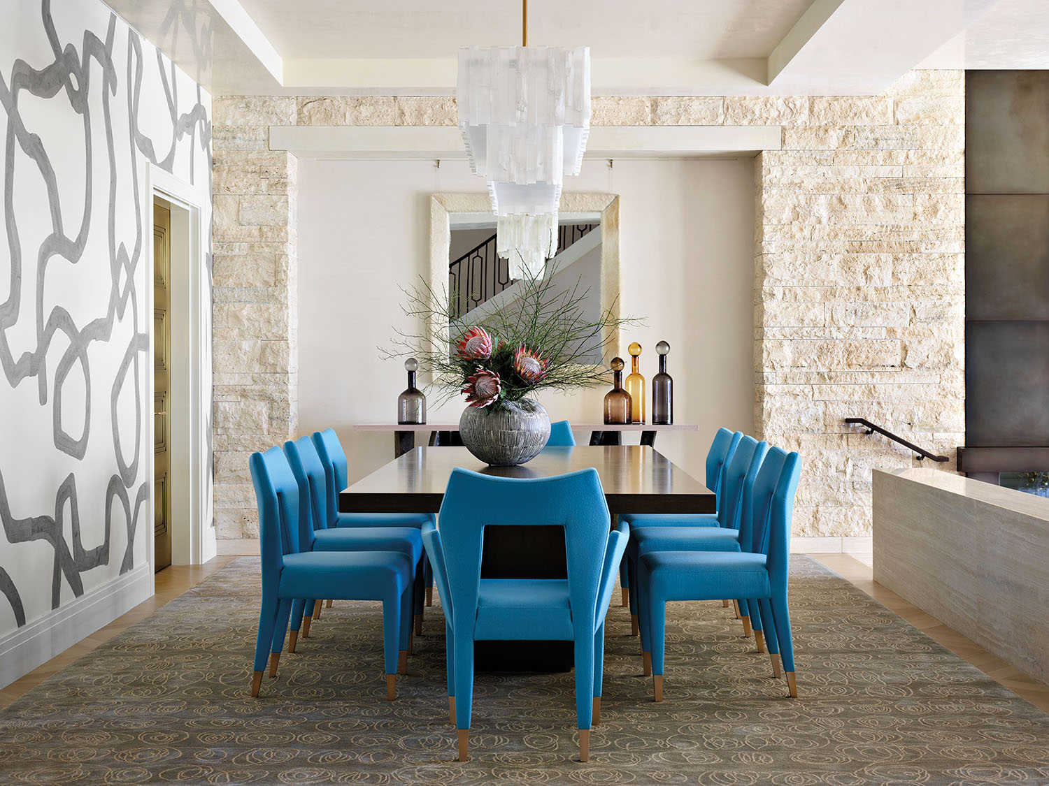 modern dining room with artful mural and blue dining chairs