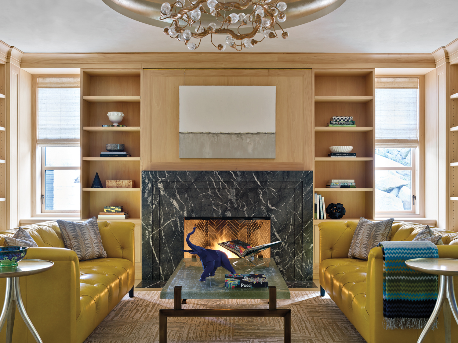 living room with yellow leather sofas and dark marble fireplace