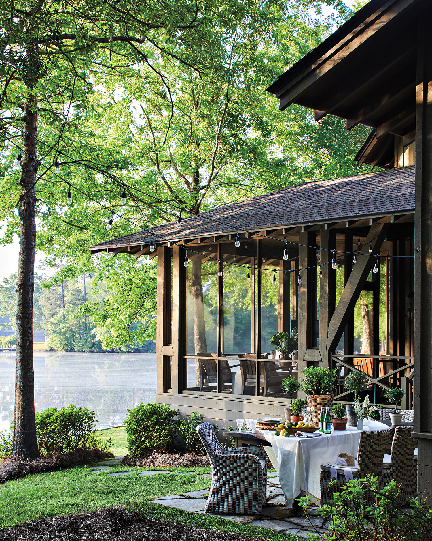 covered dining patio off of a lake house in the summer
