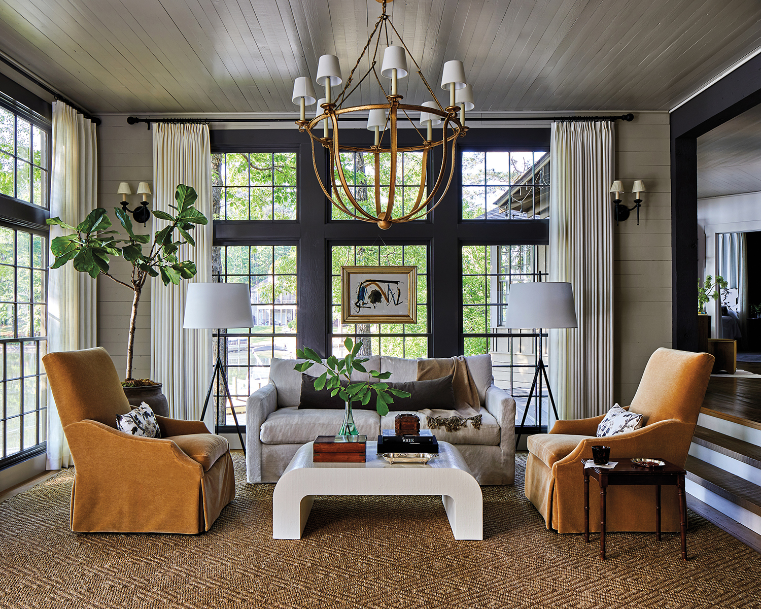traditional living room with orange slip covered armchairs and floor-to-ceiling windows
