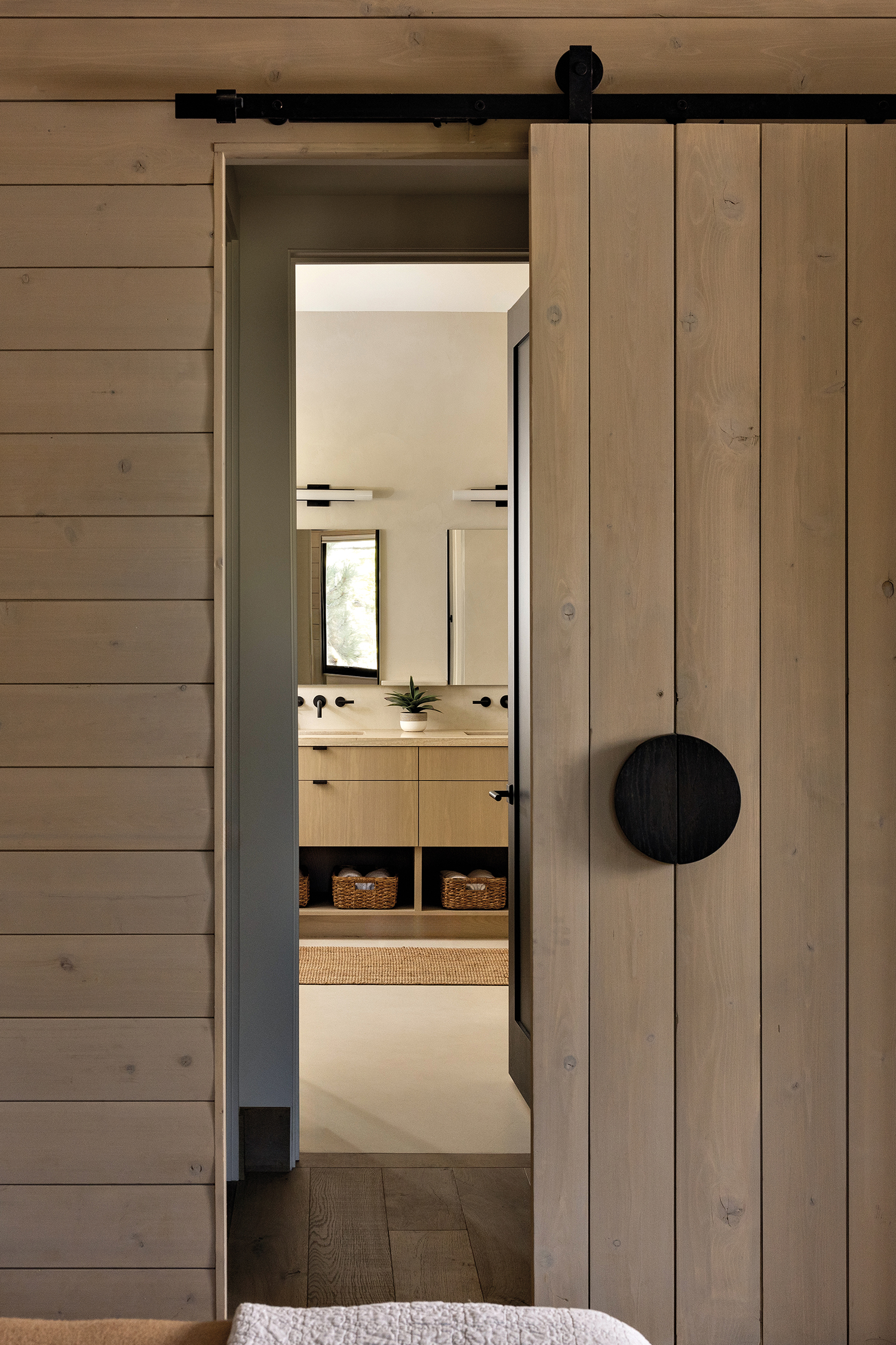 barn door in front of minimalist primary bath