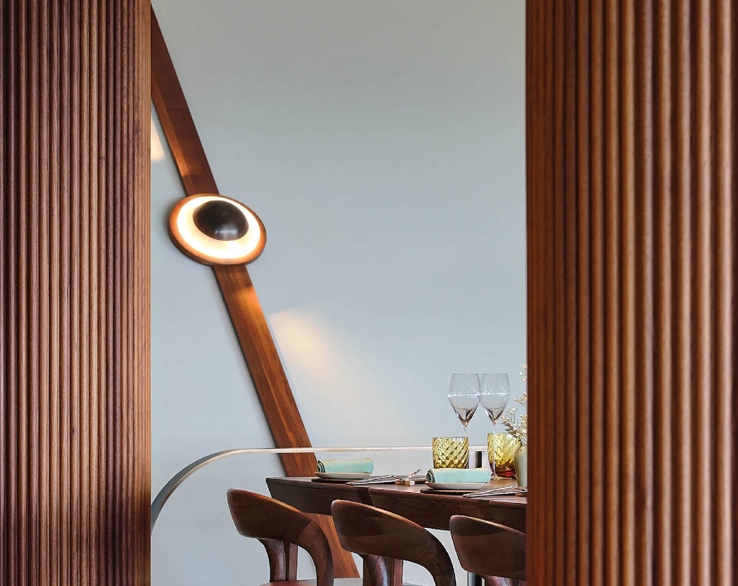 A wooden table with chairs and a lamp