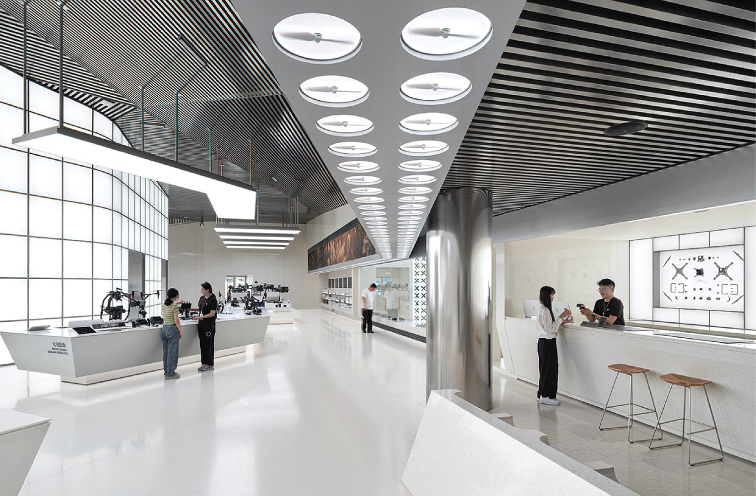 people around a white counter and underneath white fluorescent lights